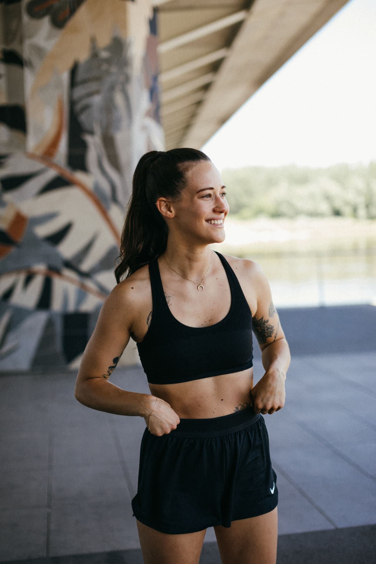 Fit smiling woman in athletic wear outdoors after a workout