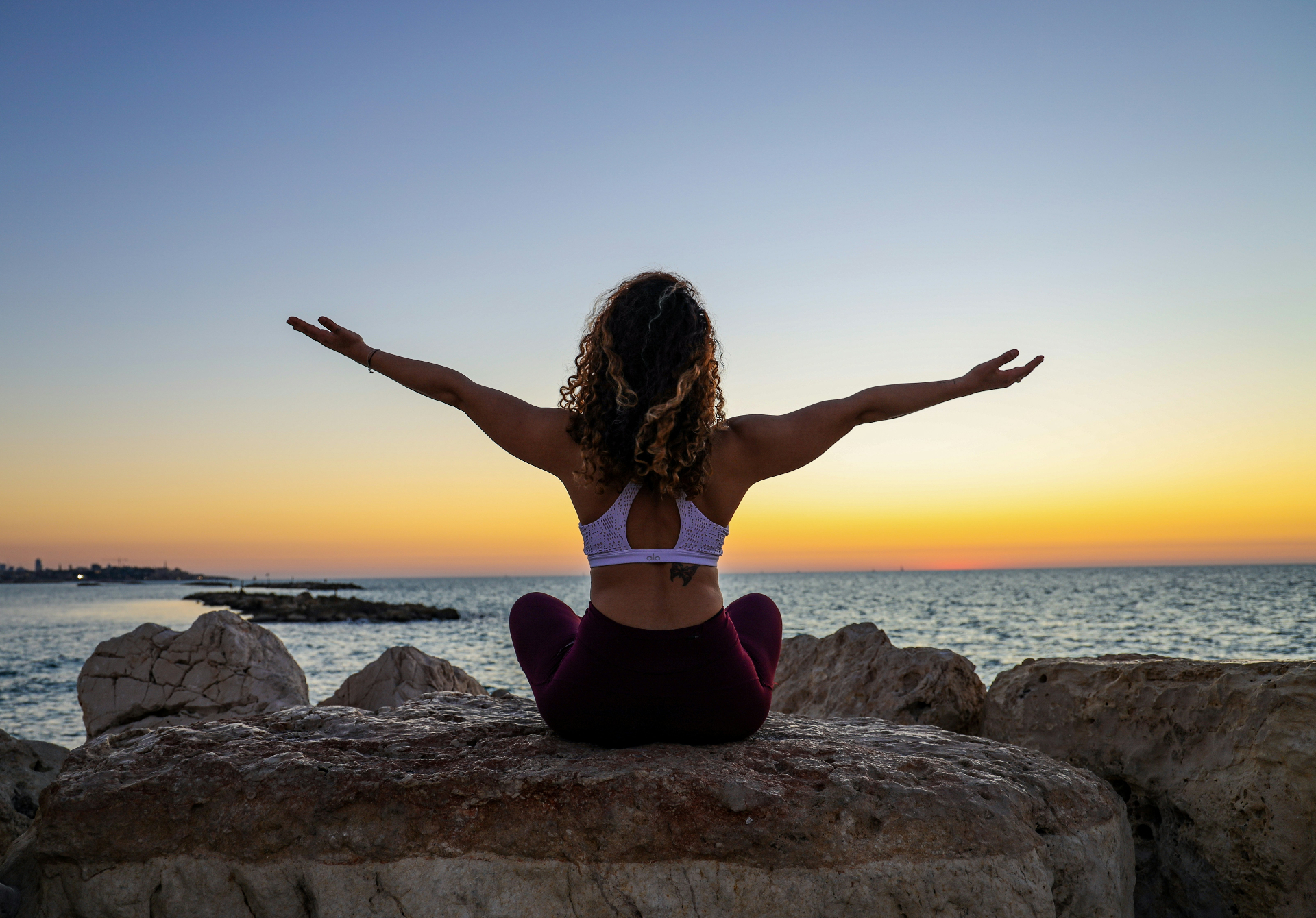 Woman practicing yoga at sunset, embodying strength and balance